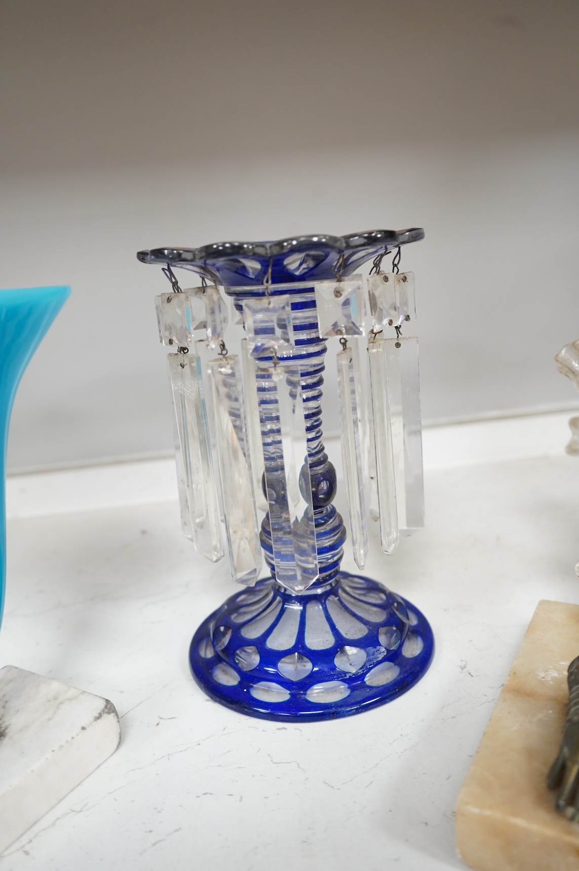 A late 19th century blue overlay glass table lustre and two late 19th century cornucopia shaped glass and brass mounted vases on stands